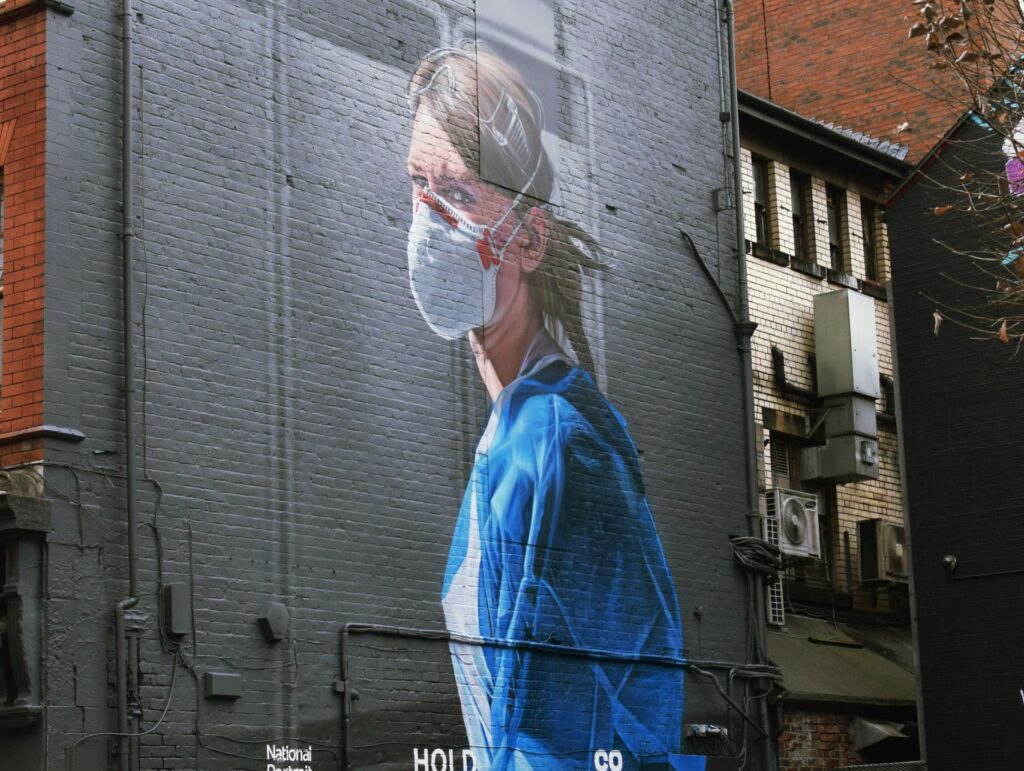 A mural of a medical professional wearing a protective mask and scrubs. Digiboost offers HIPAA compliant data security solutions for your medical data. 