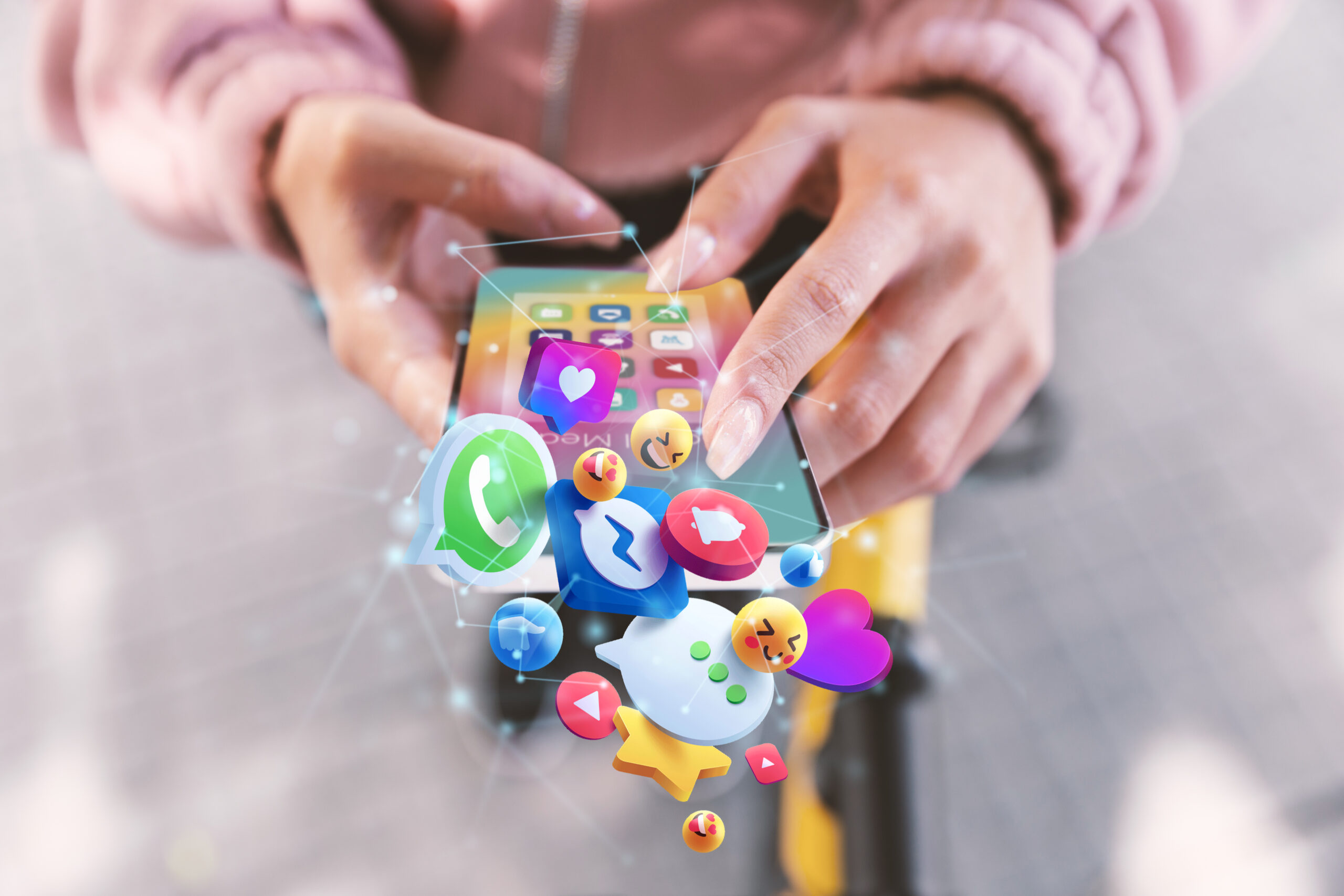hands holding a smartphone showing 3D social media icons. Digiboost is here to help you in your multilingual marketing strategy.