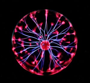 Close-up of a plasma globe with vibrant neon sparks against a dark background. AI Tools for Marketing.